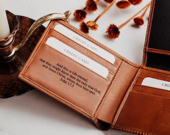 May include: Open brown leather wallet with multiple card slots. The wallet has the words "CREDIT CARD" printed on white cards. The inside of the wallet has the text "And this is life eternal, that they might know thee the only true God, and Jesus Christ, whom thou hast sent. John 17:3."