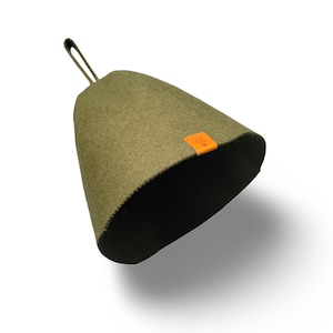 May include: Olive green sauna hat with a loop for hanging. The hat has a conical shape and a small orange tag on the side. The hat is made of a felt-like material.