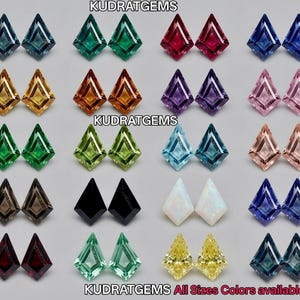 May include: A collection of kite-shaped faceted gemstones arranged in pairs, featuring a wide variety of colors including blue, green, red, yellow, purple, pink, black, and white. The text KUDRATGEMS is visible at the top and bottom.