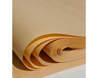 May include: A stack of light brown paper sheets rolled up. The paper is thin and has a slightly textured surface.