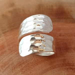 以下が含まれることがあります： ハンマーで叩いた銀のラップリング。リングは指に巻き付ける2つの金属片でできています。金属はハンマーで叩いたような質感です。