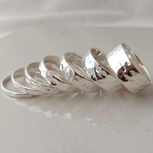 May include: A set of five silver hammered stacking rings. The rings are all different sizes and are stacked on top of each other.