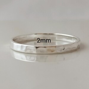 May include: A silver hammered ring with a 2mm width.