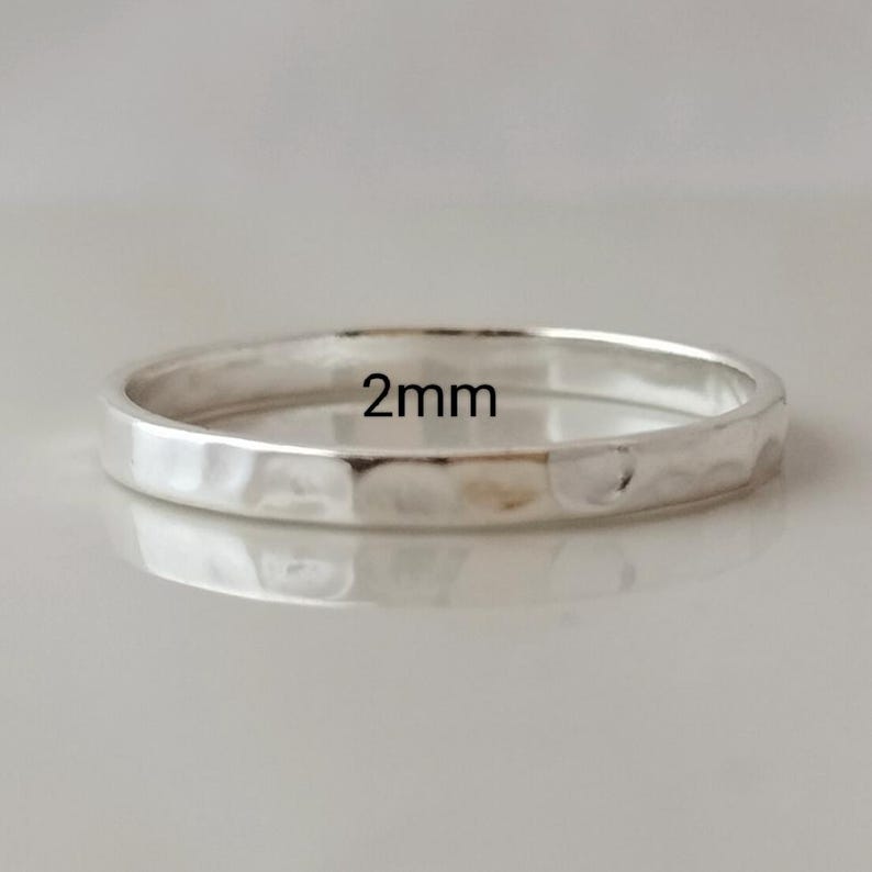 May include: A silver hammered ring with a 2mm width.