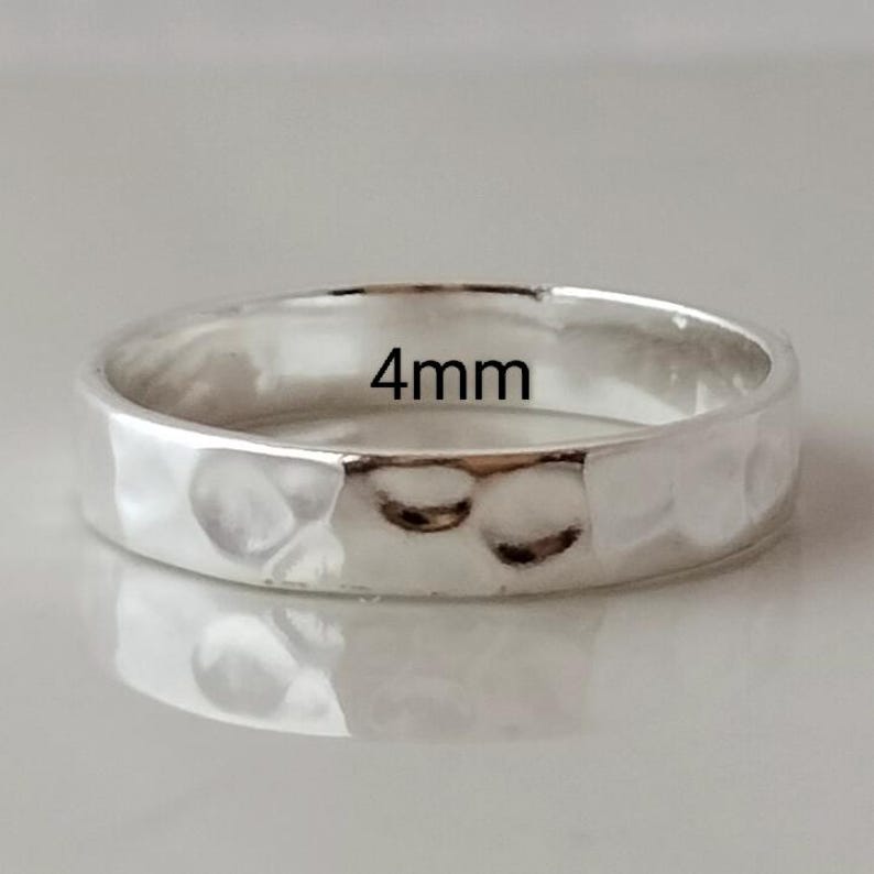 May include: A silver hammered band ring with a 4mm width.