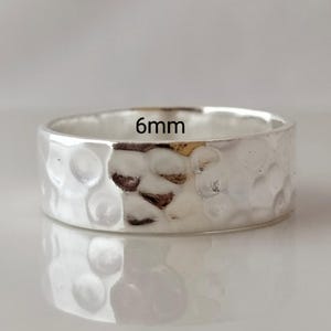 May include: A silver hammered band ring with a 6mm width.