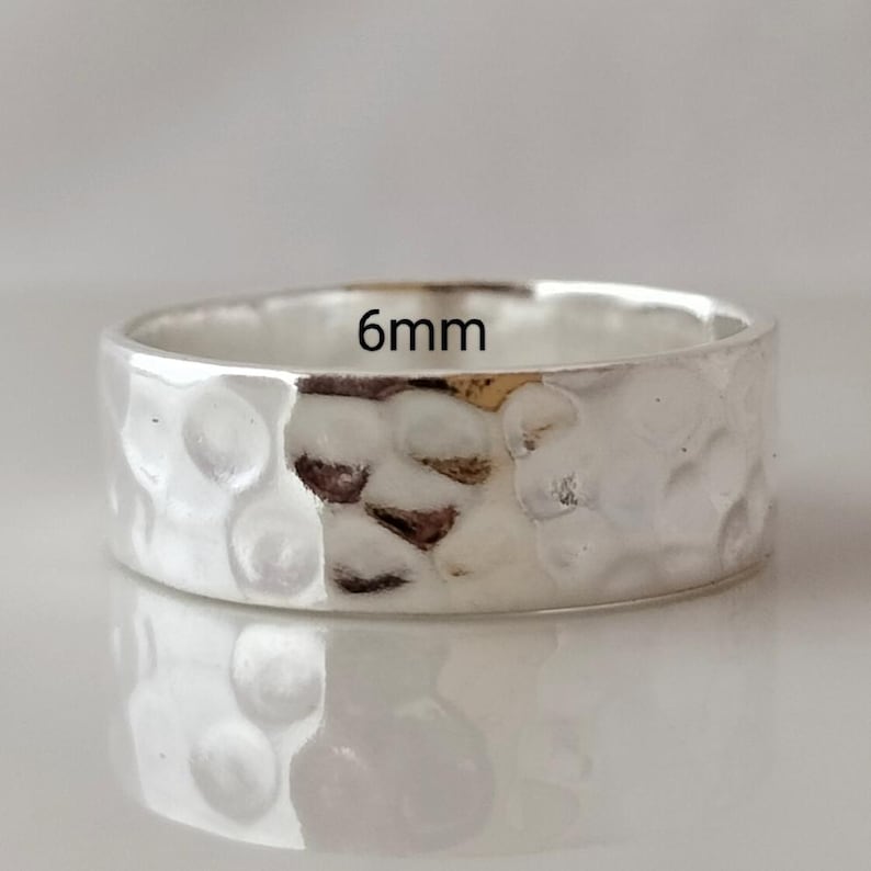 May include: A silver hammered band ring with a 6mm width.
