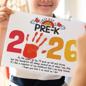 Peut inclure: Une affiche rectangulaire blanche avec le texte First Day of Pre-K, un arc-en-ciel et une pomme. L'année 2026 est imprimée en grands chiffres rouges et jaunes, avec une empreinte de main rouge remplaçant le zéro. Un poème est en bas.