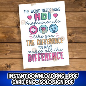 May include: A white print with the text "THE WORLD NEEDS MORE HDI Professionals" and "THE DIFFERENCE YOU MAKE makes all the DIFFERENCE". The design includes medical symbols and hearts. The print is on a wooden surface.