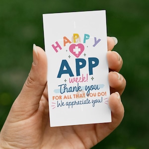 May include: A white card with the text "HAPPY APP week! Thank you FOR ALL THAT YOU DO! We appreciate you!" in various colors. The card features a heart with a cross symbol.