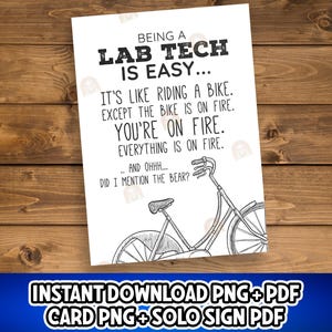 May include: A white card with black text that reads "BEING A LAB TECH IS EASY..." followed by humorous text about riding a bike. A black and white bicycle illustration is also present. The card is on a wooden surface.