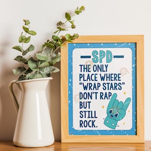 May include: A framed print with the text "SPD - The only place where 'wrap stars' don't rap but still rock." The print has a blue border with white stars and a cartoon hand making a rock-and-roll gesture.