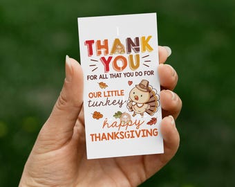 Könnte beinhalten: Eine weiße Karte mit den Worten "THANK YOU" in Orange, Braun und Gelb, mit dem Text "FOR ALL THAT YOU DO FOR OUR LITTLE TURKEY happy THANKSGIVING". Außerdem ist eine Cartoon-Truthahn mit Hut abgebildet.
