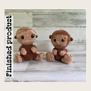 May include: Two small, handmade crochet monkey dolls with soft, plush brown yarn. Each doll features large, round green eyes, small ears, and a seated posture. The text "Finished product" is printed vertically in black on the left side of the image.