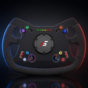 Puede incluir: Un volante de carreras negro con agarre texturizado, que presenta un centro circular con un logotipo del número 5 en blanco y rojo. El volante incluye múltiples botones de colores, dos diales giratorios rojos y una tira de luz LED horizontal.