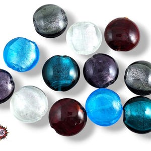 Può includere: Una collezione di perline di vetro rotonde e colorate nei toni del blu, viola, argento, bianco e bordeaux. Le perline hanno una finitura lucida e sono disposte su sfondo bianco. Ideali per la creazione di gioielli e artigianato.