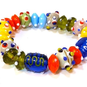 Puede incluir: Una colorida pulsera de cuentas de vidrio con una variedad de formas y colores. Las cuentas incluyen rojo, amarillo, azul, verde y blanco, con lunares y diseños a rayas. Una joya única.