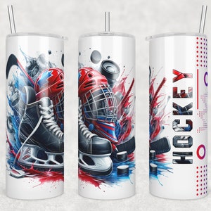 May include: A white tumbler with a hockey-themed design. The design features a hockey helmet, skates, and a hockey stick with red, blue, and white paint splatters. The text "HOCKEY" is printed on the tumbler.