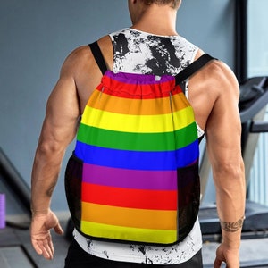 May include: A rainbow drawstring backpack with a mesh pocket on each side. The backpack is made of a durable, water-resistant material and features a comfortable, adjustable shoulder strap.