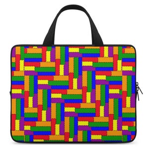 Puede incluir: Bolso rectangular para portátil con un colorido diseño de patchwork. El patrón presenta rectángulos en rojo, naranja, amarillo, verde, azul y morado, cosidos entre sí. Tiene un asa negra y una cremallera.
