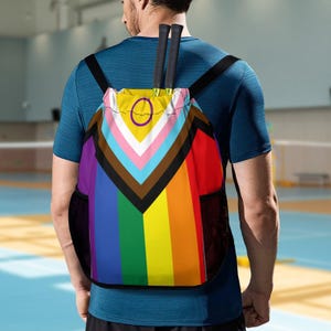 May include: A drawstring backpack with a rainbow and black and brown stripes design. The backpack has a mesh pocket on the side and a black drawstring.