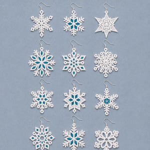 May include: A collection of twelve white snowflake-shaped earrings arranged in four rows of three. Each earring features intricate lace-like patterns, with some designs incorporating small teal blue accents within the white thread structure.