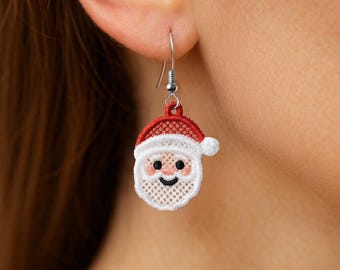 May include: A single Santa Claus earring with a red and white design. The earring features a smiling Santa face with pink cheeks and a black smile. The Santa hat is red with a white trim. The earring is made of lace and has a silver hook.