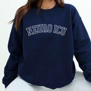 May include: Navy blue sweatshirt with white text that reads "NEURO ICU" in a collegiate font.