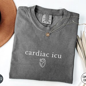 Pu&ograve; includere: Una maglietta grigia scura con il testo "cardiac icu" e una piccola grafica a forma di cuore stampata in bianco. La maglietta &egrave; realizzata in un materiale morbido e confortevole.
