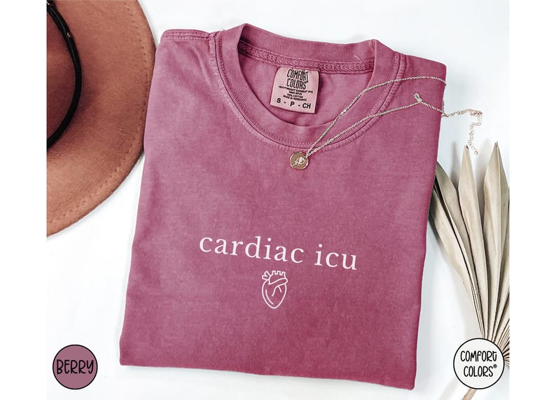 Pu&ograve; includere: Una maglietta color granata con il testo "cardiac icu" e una piccola grafica a forma di cuore stampata in bianco. La maglietta &egrave; realizzata da Comfort Colors.