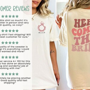 May include: A white t-shirt with the text "HERE COMES THE BRIDE" in pink and red lettering on the back. The front of the shirt has a small ring design with the text "Mrs. Smith". The shirt is available in ivory.