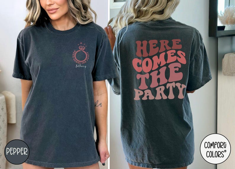 May include: A black t-shirt with a ring and the text "Here Comes The B*tch" on the front and the text "Here Comes The Party" on the back.