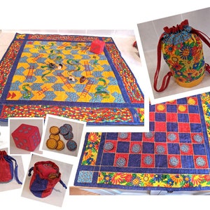 Könnte beinhalten: Ein Set aus bunten, gesteppten Spielbrettern mit einem Schlangen-und-Leitern-Design, einem Dame-Design und einem Kordelzugbeutel. Die Spielbretter sind aus Stoff und haben einen floralen Rand. Der Kordelzugbeutel ist rot und blau mit einem Blumenmuster.