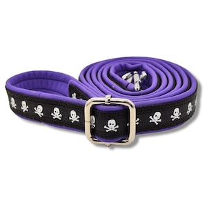 Op de afbeelding: Paarse hondenriem met een zwart-witte schedel en gekruiste beenderen patroon.