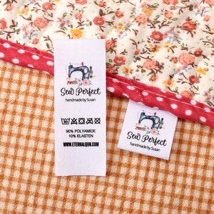 Könnte beinhalten: Weißes Stofflabel mit schwarzem Text, der "Sew Perfect handmade by Susan" lautet. Das Etikett zeigt auch eine Schwarzweißillustration einer Nähmaschine und ein Waschanleitungssymbol. Das Etikett befindet sich auf einem braunen und weißen karierten Stoff.