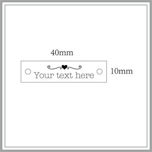 May include: A white rectangular label with a black heart and decorative swirls. The label is 10 cm long and 4 cm wide. The text on the label reads "Your text here".