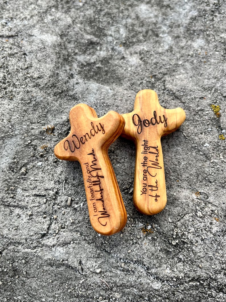 May include: Two wooden crosses with rounded edges, engraved with names and inspirational phrases. One cross reads "Wendy, I am fearfully and wonderfully made." The other says "Jody, You are the light of the World."