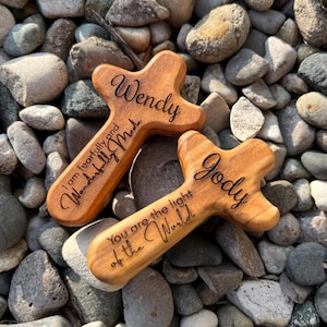 May include: Two wooden crosses with rounded edges, engraved with names and inspirational quotes. One reads "Wendy, I am fearfully and wonderfully made." The other says "Jody, You are the light of the World."