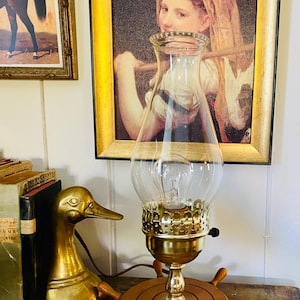 Vintage electric boudoir lamp, shaped like an oil lamp. Working condition, wooden ship wheel base with clear glass shade.  Maritime decor.
