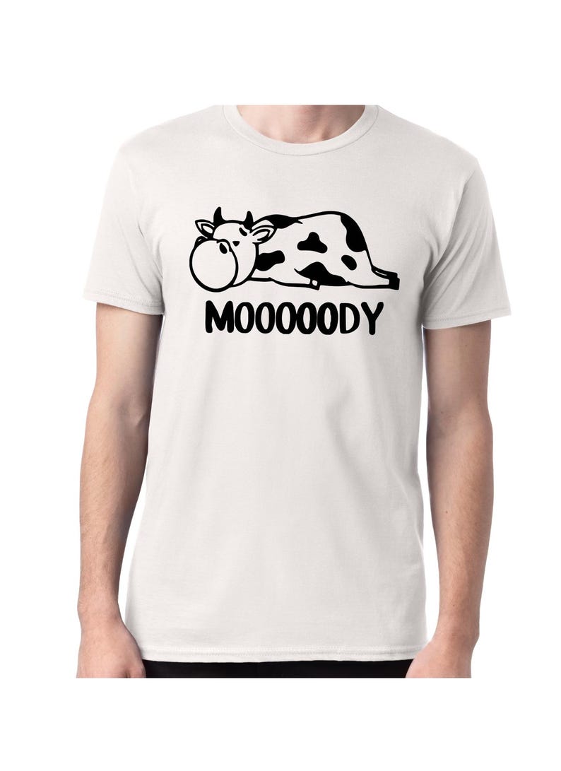 May include: A white t-shirt with a black cartoon cow lying down and the text 'MOOOOODY'.