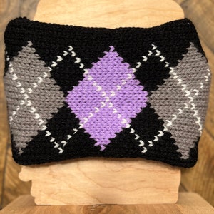 May include: A black, gray, and purple knitted headband with a diamond pattern.