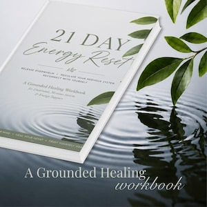 May include: A book titled "21 Day Energy Reset" with the subtitle "A Grounded Healing Workbook". The cover features text about releasing overwhelm and reconnecting with yourself. Green leaves and water ripples are in the background.