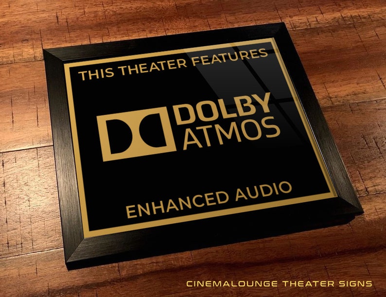 May include: Black framed sign with gold lettering that reads "This theater features Dolby Atmos Enhanced Audio".