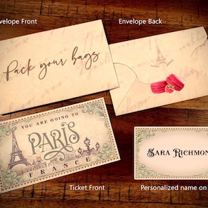 May include: A vintage-style ticket with the text "You are going to Paris, France" and a drawing of the Eiffel Tower. The ticket is on a wooden surface with a white envelope that says "Pack your bags" and a smaller white envelope with a drawing of the Eiffel Tower and macarons.