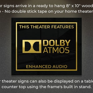 May include: A black framed sign with gold lettering that reads "This Theater Features Dolby Atmos Enhanced Audio". The sign is 8 inches by 10 inches and is ready to hang.