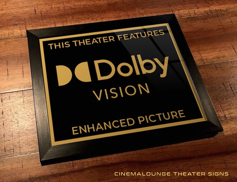 May include: Black framed sign with gold lettering that reads "This theater features Dolby Vision Enhanced Picture".