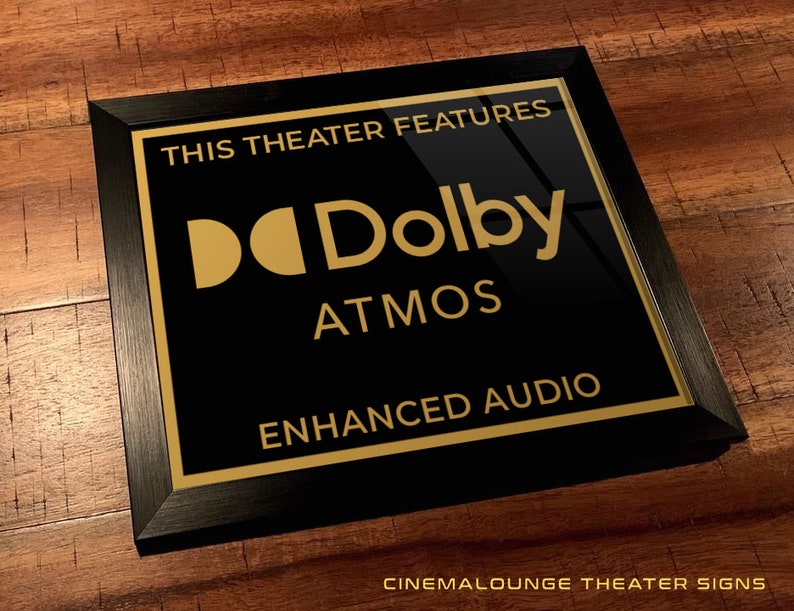 K&ouml;nnte beinhalten: Schwarz gerahmtes Schild mit goldener Aufschrift "This theater features Dolby Atmos Enhanced Audio".