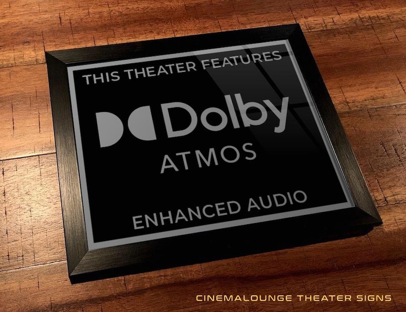 May include: Black framed sign with silver text that reads "This theater features Dolby Atmos Enhanced Audio".
