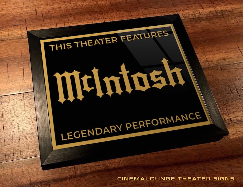 May include: Black framed sign with gold lettering that reads "This Theater Features McIntosh Legendary Performance".