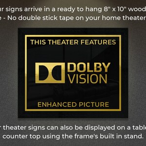 May include: A black framed sign with gold lettering that reads "This Theater Features Dolby Vision Enhanced Picture". The sign is 8 inches by 10 inches and is ready to hang.